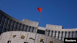 Bendera China berkibar di luar kantor Bank Sentral China di Beijing (Foto: dok).