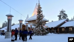 Visitors walk in Santa Claus Village, around 8 kilometers (5 miles) north of Rovaniemi, Finland, Dec. 15, 2015. Most kids learn Santa Claus comes from the North Pole. But where exactly is a matter of much debate in Finland, Sweden and Norway.