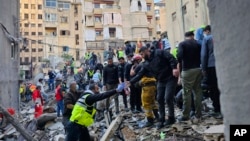 Tim penyelamat mencari korban di lokasi serangan udara Israel yang menargetkan sebuah gedung di Beirut, Lebanon, Selasa, 26 November 2024. (Hassan Ammar/AP)