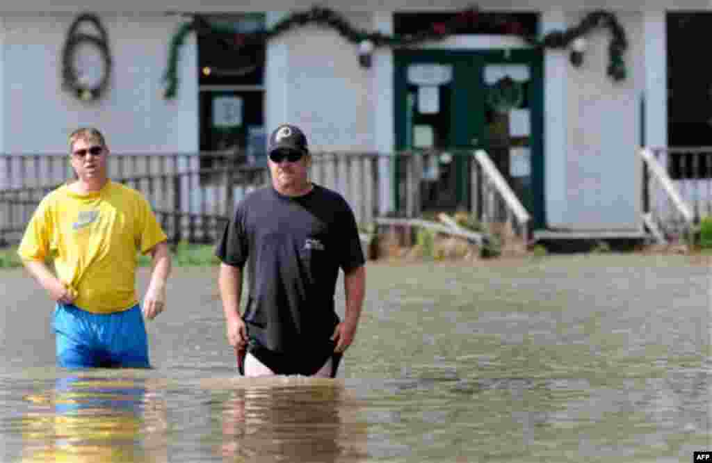 Brian Brown, left, of California, Md., and Ryan Frederick, of Hollywood, Md., wade through floodwater in Leonardtown, Md., after Hurricane Irene Sunday, Aug. 28, 2011. (AP Photo/Steve Ruark)