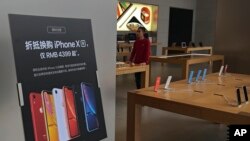 FILE - An iPhone XR promotion board is displayed at an Apple retail store in Beijing, China, Jan. 3, 2019. Apple is temporarily closing its 42 stores in mainland China, one of its largest markets, amid the coronavirus outbreak.