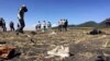 People walk past a part of the wreckage at the scene of the Ethiopian Airlines Flight ET 302 plane crash, near the town of Bishoftu, southeast of Addis Ababa, March 10, 2019.