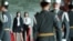 Two Chinese university students from Beijing watch Oct. 26 as military guards at Taipei's Sun Yat-sen Memorial Hall exchange their hour-long shift. The two were among a 14-member delegation offering a donation to the local Chinan University.