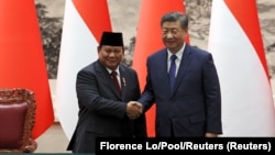 Presiden China Xi Jinping dan Presiden Prabowo Subianto berjabat tangan selama upacara penandatanganan di Balai Agung Rakyat di Beijing, China, pada 9 November 2024. (Foto: Florence Lo/Pool/Reuters)