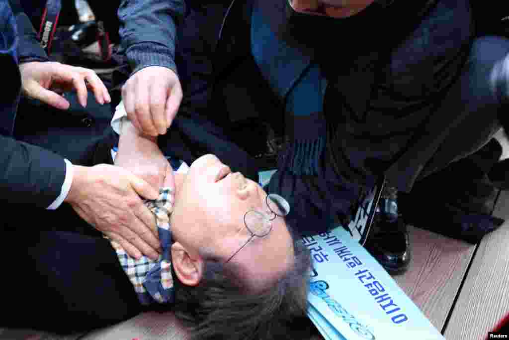 South Korea&#39;s opposition party leader Lee Jae-myung falls after being attacked by an unidentified man during his visit to Busan.