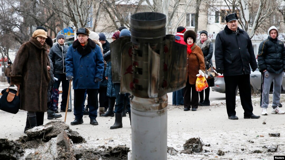 Gradjani posmatraju ostatke granate na ulici u Kramatorsku u istočnoj Ukrajini, 10. februara 2015. 