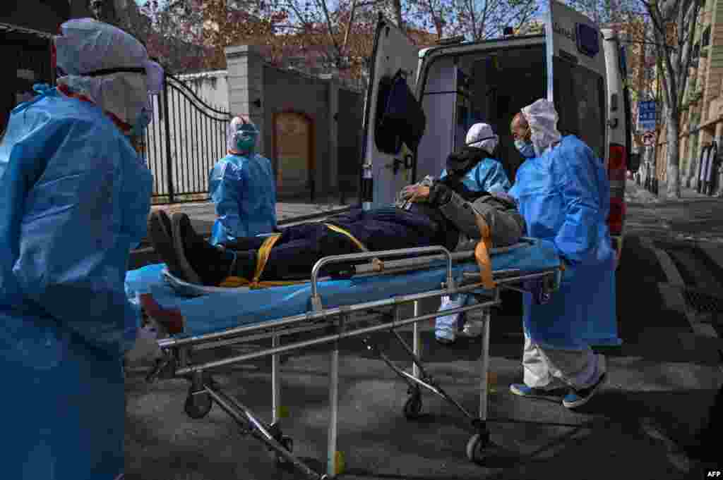 Medical workers in protective clothes are seen carrying a patient suspected of having the new coronavirus in Wuhan, in Hubei province, China.