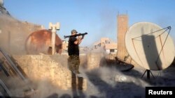 FILE - An American volunteer fighter of Syrian Democratic Forces fires an RPG during a battle with Islamic State militants in Raqqa, Syria, Oct. 6, 2017. (REUTERS/Erik De Castro)