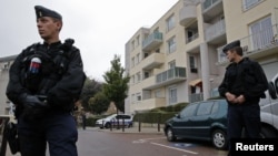 French gendarmes secure a garage entrance, where an anti-terrorist raid was conducted four days ago, in Torcy near Paris, October 10, 2012.