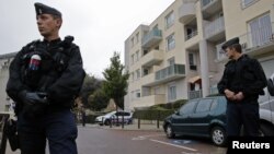 Polisi Perancis berjaga di depan pintu masuk sebuah garasi parkir di Torcy, kawasan pingiran Paris (10/10).