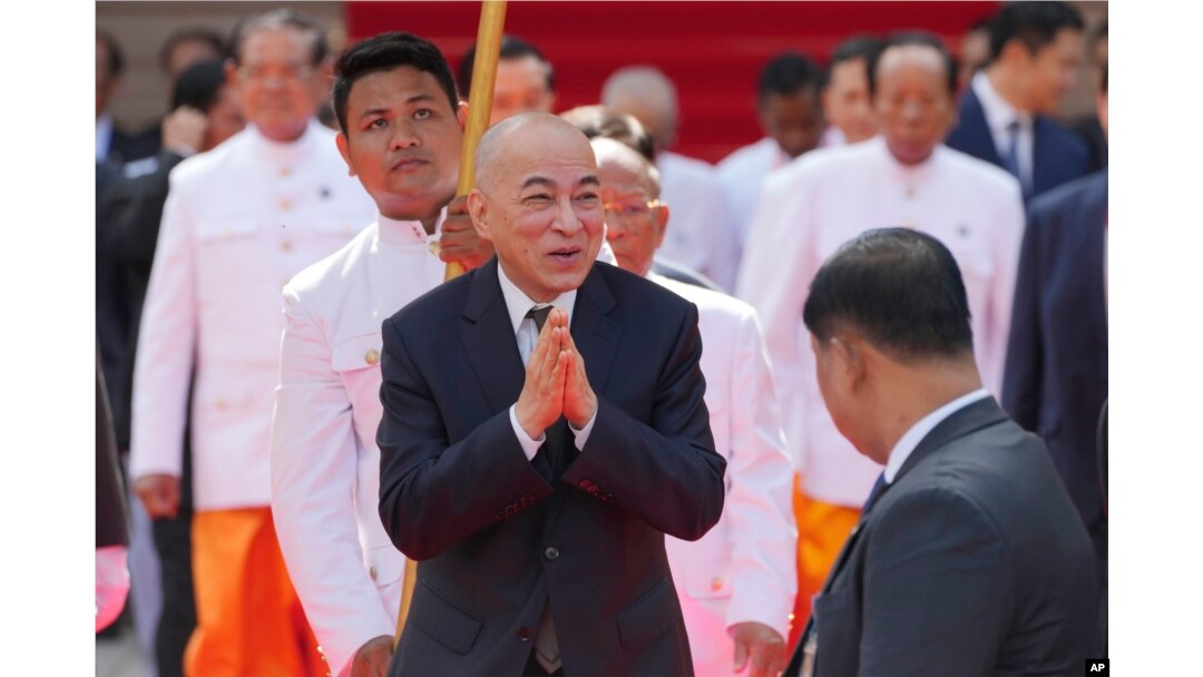 Raja Kamboja Norodom Sihamoni, tengah, menyapa anggota parlemen sebelum sesi foto di depan Majelis Nasional di Phnom Penh, Kamboja, Senin, 21 Agustus 2023. (Foto: AP/Heng Sinith)