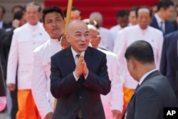 Raja Kamboja Norodom Sihamoni, tengah, menyapa anggota parlemen sebelum sesi foto di depan Majelis Nasional di Phnom Penh, Kamboja, Senin, 21 Agustus 2023. (Foto: AP/Heng Sinith)