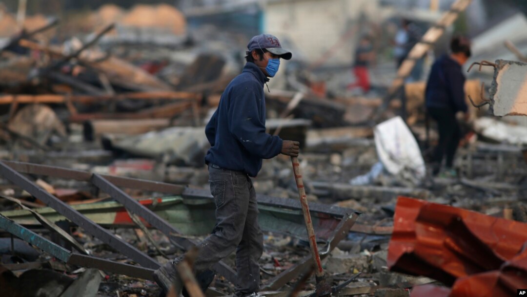 A man walks through the scorched ground of the open-air San Pablito fireworks market, in Tultepec, outskirts of Mexico City, Mexico, Dec. 20, 2016.