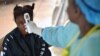 Une jeune fille soupçonnée d'être infectée par le virus Ebola fait prendre sa température dans un hôpital de Kenema, en Guinée, le 16 août 2014.