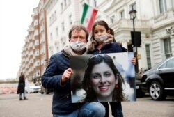 Richard Ratcliffe, esposo de la trabajadora humanitaria británico-iraní Nazanin Zaghari-Ratcliffe, y su hija Gabriella protestan frente a la embajada iraní en Londres, Gran Bretaña, 8 de marzo de 2021.