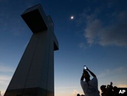 FILE—A total solar eclipse is seen above the Bald Knob Cross of Peace August 21, 2017, in Alto Pass, Ill.