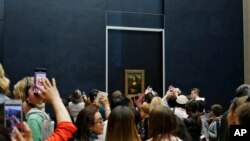 Tourists wait to see Leonardo da Vinci's painting Mona Lisa, at the Louvre museum, in Paris, Oct. 23, 2019.