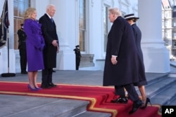 Presiden Joe Biden (tengah kiri), dan ibu negara Jill Biden (kiri) menyapa Presiden terpilih Donald Trump (tengah kanan) dan Melania Trump di Gedung Putih, Washington, D.C, Senin, 20 Januari 2025. (Evan Vucci/AP)