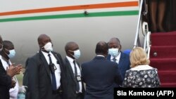 Le Premier ministre ivoirien Amadou Gon Coulibaly accueilli par le Président Alassane Ouattara à l'aéroport Félix Houphouët-Boigny d'Abdijan le 2 juillet 2020. (Photo by SIA KAMBOU / AFP)