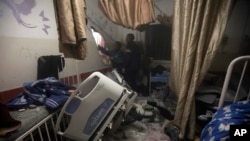 FILE - Palestinian paramedics inspect damage in the patient rooms caused by Israeli strikes on the maternity ward at Nasser Hospital in the town of Khan Younis, southern Gaza Strip, Dec. 17, 2023.