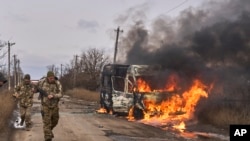 En esta foto distribuida por la 10ma Brigada de Montaña "Edelweiss", de Ucrania, soldados ucranianos pasan junto a un bus impactado por un dron ruso cerca de Bajmut, región de Donetsk, Ucrania, 23 de noviembre de 2023. [Foto: Archivo / AP]. 