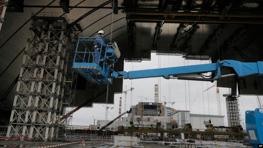 Construction workers assist in the assembly of a gigantic steel arch to cover the remnants of the exploded reactor at the Chernobyl nuclear power plant in Chernobyl, Ukraine, March 23, 2016.