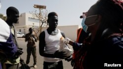 FILE - Faty, from the Village Pilote association, wears a protective face mask during distribution of food to street children amid an outbreak of the coronavirus disease, in Dakar, Senegal, April 1, 2020.