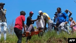 Une personne ayant reçu une balle de la police spéciale swazie est transportée sur une civière à Mbabane, le 20 octobre 2021.