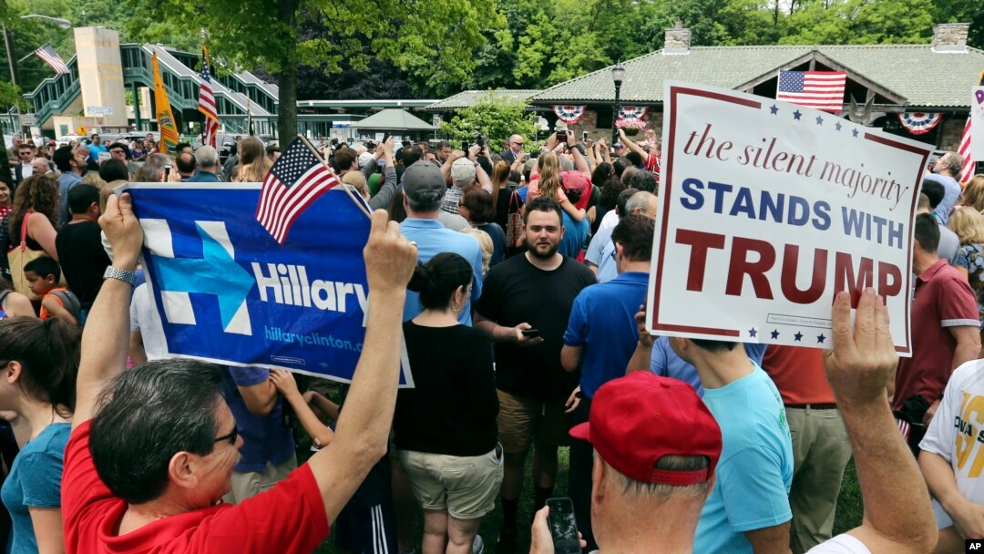 Pendukung Hillary Clinton dan pendukung Donald Trump berdampingan membawa poster dukungan masing-masing dalam parade Hari Pahlawan di Chappaqua, New York. (Foto: Dok)