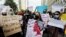 People carry signs to condemn the violence against women and girls during a protest in Karachi, July 30, 2021