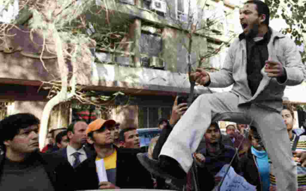 Un manifestantes se alza sobre un coche y grita eslóganes contra el líder libio Gadafi.