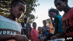 FILE - Displaced children from Western Tigray wait to receive food outside a classroom in the school where they are sheltering in Tigray's capital, Mekele, Feb. 24, 2021. Hunger and sexual violence have continued to rise dramatically since then.