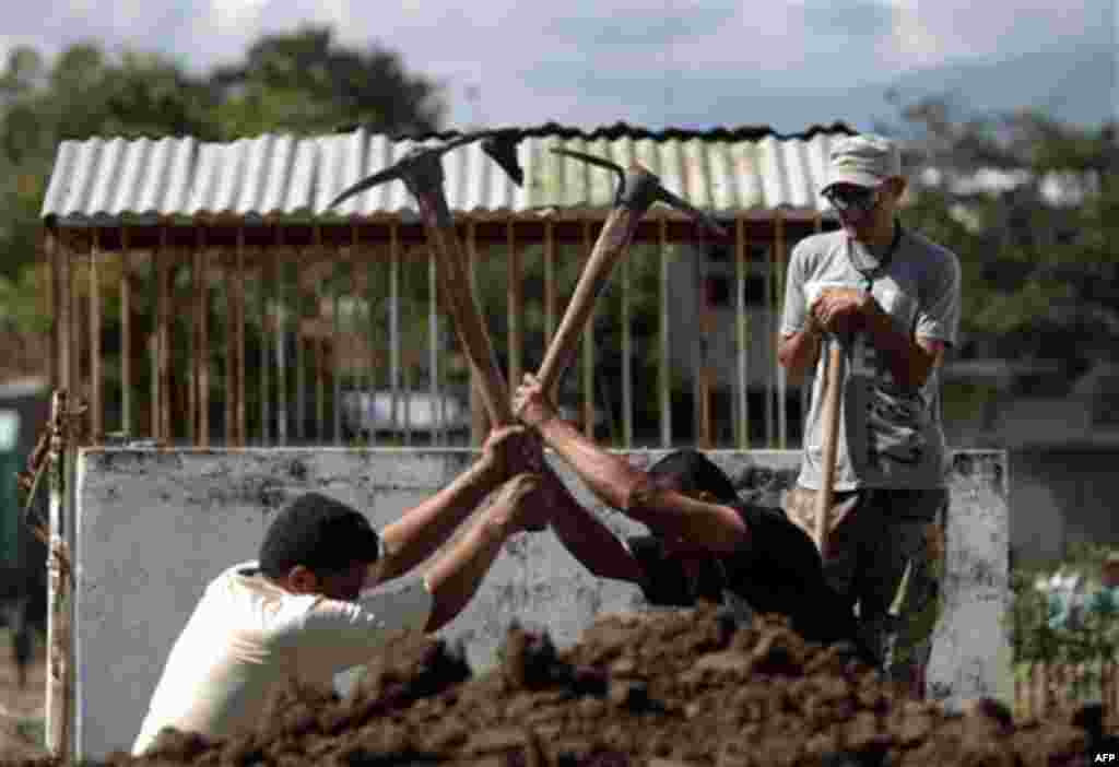 Relatives prepare graves for their family members who died in a prison fire, in Comayagua, Honduras, Friday Feb. 17, 2012. As workers cleaned up the rubble of the century's deadliest prison fire whose death toll rose to 356 Friday, a collective rage built