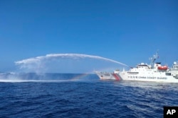 Kapal Garda Pantai China, kanan, menggunakan meriam airnya terhadap kapal Biro Perikanan dan Sumber Daya Perairan Filipina (BFAR), saat mendekati Scarborough Shoal di Laut China Selatan yang disengketakan, pada 9 Desember 2023. (Foto: PCG via AP)