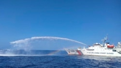 Sebuah kapal Penjaga Pantai China, di sebelah kanan, menggunakan meriam airnya terhadap kapal Biro Perikanan dan Sumber Daya Perairan Filipina (BFAR), saat mendekati Scarborough Shoal di Laut China Selatan yang disengketakan, pada 9 Desember 2023. (Foto: via AP)