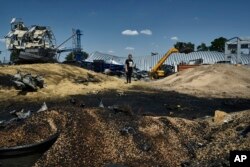 Olha berdiri di antara puing-puing bangunan penyimpanan pertanian yang hancur akibat serangan Rusia di wilayah Odesa, Ukraina, pada 21 Juli 2023. (Foto: AP)