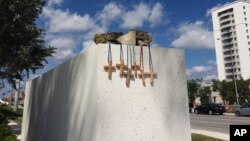 Six crosses are placed at a makeshift memorial on the Florida International University campus in Miami, March 17, 2018, near the scene of a pedestrian bridge collapse that killed at least six people on March 15. 