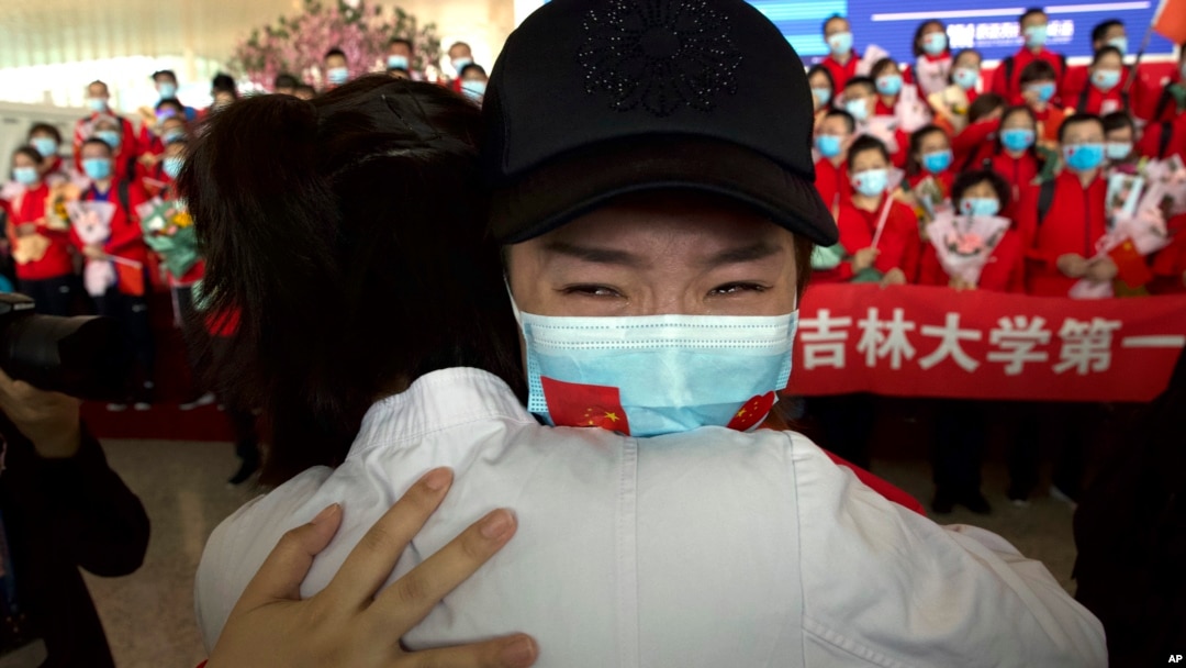 A medical worker from China's Jilin Province reacts as she prepares to return home at Wuhan Tianhe International Airport in Wuhan in central China's Hubei Province, Wednesday, April 8, 2020. Within hours of China lifting an 11-week lockdown on the…