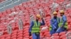 Para pekerja konstruksi berdiri di bangku penonton stadion al-Bayt di Doha, yang dipersiapkan untuk menggelar pertandingan Piala Dunia 2022, dalam proses pembangunan stadion pada 17 Desember 2019. (Foto: AFP/Giuseppe Cacace)