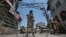 Indian policemen stand guard behind concertina wire during a strike called by separatists to mark the death anniversaries of chief cleric of Kashmir, Moulana Mohammad Farooq and Abdul Gani Lone, a Kashmiri separatist leader, in Srinagar, May 21, 2018.