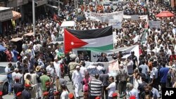 Jordanian police form a line separating the anti-government protesters (back) from government supporters during a demonstration after Friday prayers in Amman, June 10, 2011