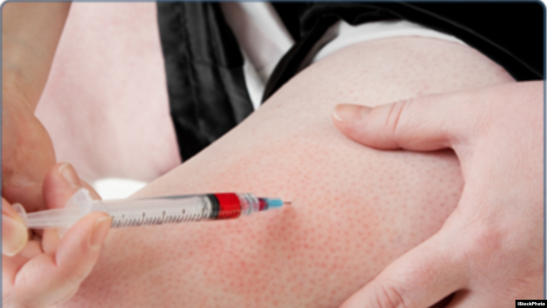 FILE - A women is seen performing an injection on herself.