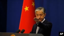 FILE - Foreign Ministry spokesperson Wang Wenbin gestures for questions during the daily briefing in Beijing, July 23, 2020. 