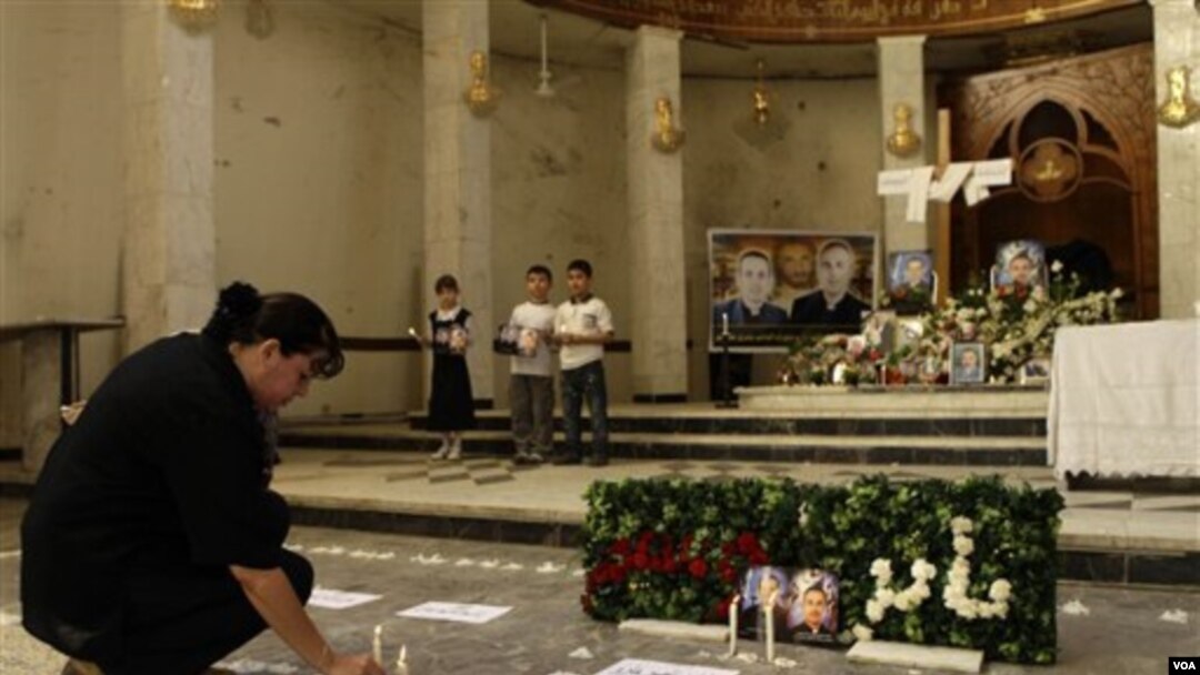 Seorang wanita menaruh lilin tanda berkabung bagi korban serangan warga Kristen di Baghdad, Irak.
