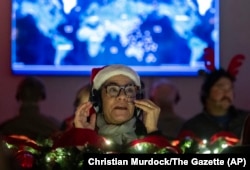 Volunteers answer phone calls from around the world, Dec. 24, 2024, at the NORAD Tracks Santa center at Peterson Space Force Base in Colorado Springs, Colorado.