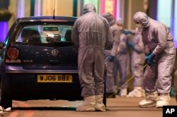 Police forensic officers work near a car at the scene after a stabbing incident in Streatham London, Feb. 2, 2020.
