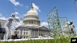 Una obra de arte exhibida fuera del Capitolio en Washington en el primer aniversario de la política de cero tolerancia de la administración Trump que separó a las familias migrantes, muestra a una madre tratando de alcanzar a su hijo. Mayo 7 de 2018.