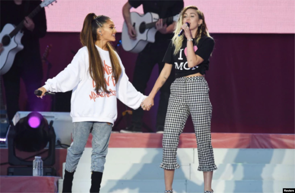 美国流行歌手爱莉安娜&middot;格兰德（Ariana Grande）和歌手、演员麦莉&middot;希拉（Miley Cyrus）在曼彻斯特慈善音乐会上演唱（2017年6月4日）。麦莉&middot;希拉曾经主演过美国迪斯尼公司出品的青少年电视情景喜剧《孟汉娜》