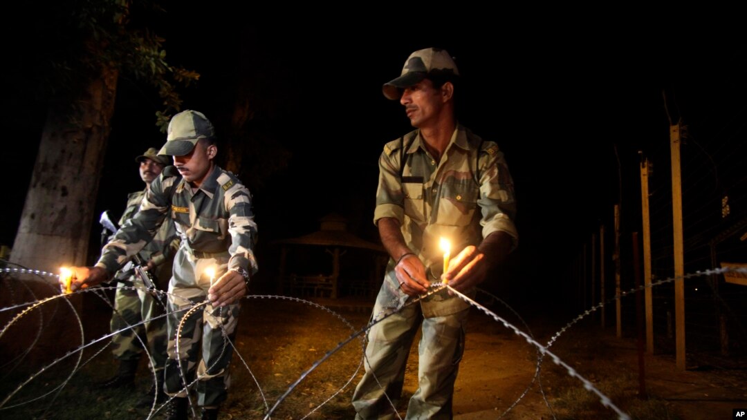 Petugas perbatasan di wilayah Ranbir Singh Pora, sekitar 33 kilometer dari kota Jammu, India, meletakkan lilin di pagar perbatasan India-Pakistan untuk persiapan perayaan Diwali (2/11).