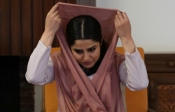 Maryam Sama, a 27-year-old member of Parliament, adjusts her headscarf during an interview with The Associated Press, in Kabul, Afghanistan, Aug. 22, 2019.